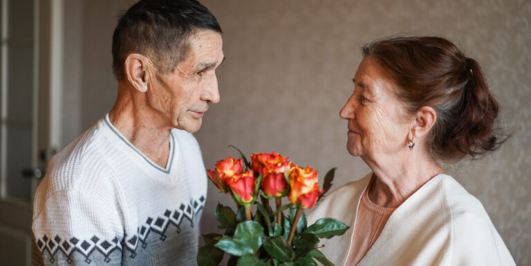 Elderly Man Giving Orange Roses to a Senior Woman in Dementia Care Katy TX