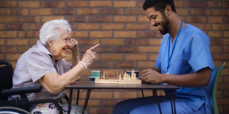 Elderly Woman Playing Chess with Skilled Nurse at Memory Care Facility