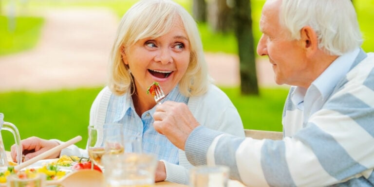 Elderly Couple Sharing a Meal Outdoors at Assisted Living Facility